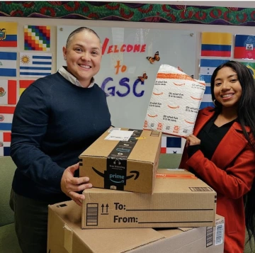 two individuals standing together holding donated items